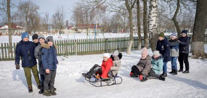 Group of children sledding in a snowy park, enjoying winter activities.