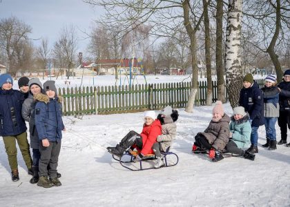 Group of children sledding in a snowy park, enjoying winter activities.